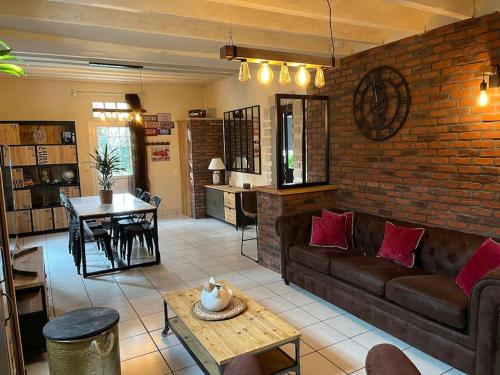 un salon avec un canapé et un mur de briques dans l'établissement Belle maison proche de chambord, à Huisseau-sur-Cosson