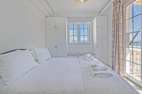- une chambre blanche avec un grand lit et des fenêtres dans l'établissement Old Fortress View Roof Top Apartment by Konnect, à Corfou