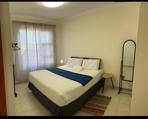 um quarto com uma cama e uma janela em MV self-catering Linden em Bloemfontein