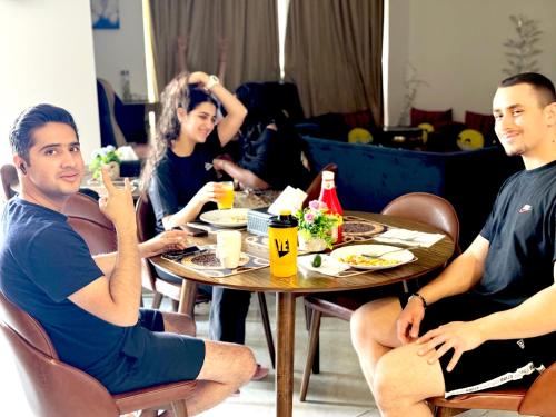 un grupo de personas sentadas en una mesa comiendo comida en Royal Beach Residences, en Dubái