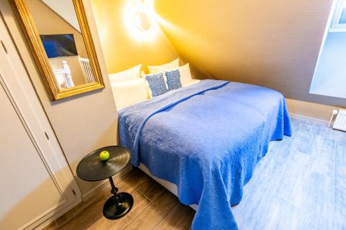 - une chambre avec un lit doté d'une couverture bleue et d'une table dans l'établissement Heefwai 2 W5, à Morsum