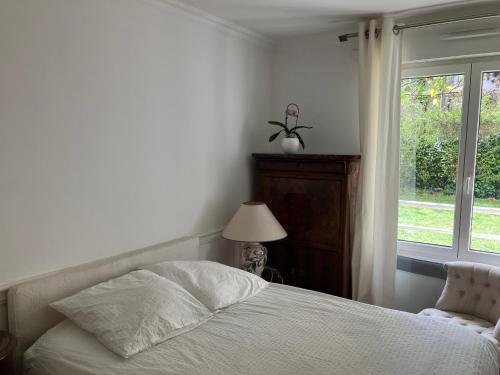 une chambre avec un lit et une fenêtre dans l'établissement Elégant appartement sur jardin à Boulogne, à Boulogne-Billancourt