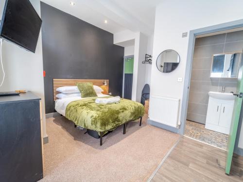 a bedroom with a bed and a sink and a television at Modern cosy retreat Pass the Keys in Beeston