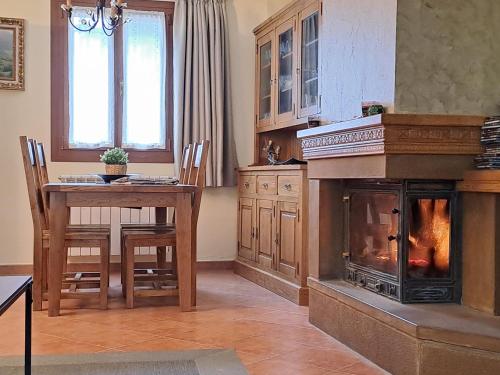 a living room with a fireplace and a dining room table at Casa Rural Torreblanca in Urroz