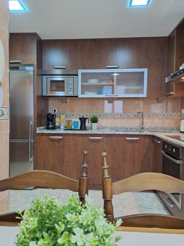a kitchen with wooden cabinets and stainless steel appliances at Casa Rural Torreblanca in Urroz