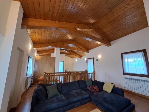 a living room with a blue couch and wooden ceilings at Casa Rural Torreblanca in Urroz