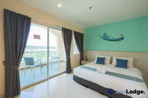 a bedroom with a bed and a balcony with a table at AnyLodge Waterfront Marina Island Pangkor in Lumut