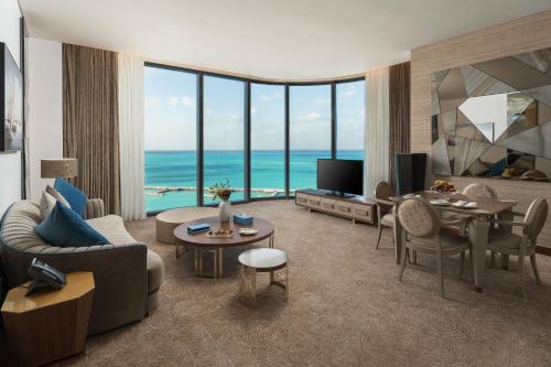 a living room with a view of the ocean at Rixos Premium Alamein in El Alamein