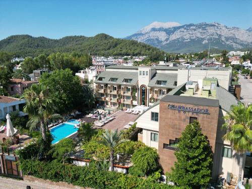 Ambassador Hotel & Spa- All Inclusive في أنطاليا: اطلالة جوية على منتجع فيه مسبح وجبال