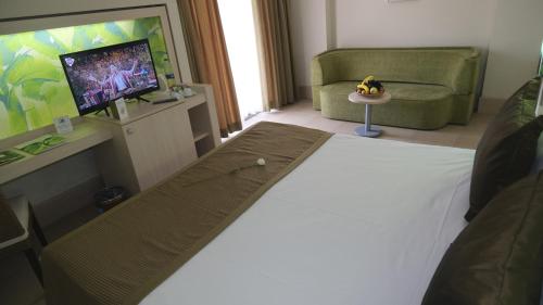 a living room with a bed and a flat screen tv at Ambassador Hotel & Spa- All Inclusive in Kemer