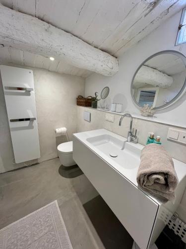 une salle de bain blanche avec un lavabo et des toilettes dans l'établissement Belle Maison de village Ramatuelle, à Ramatuelle