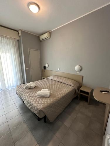 ein Schlafzimmer mit einem Bett mit zwei Handtüchern darauf in der Unterkunft Hotel Austria in Rimini