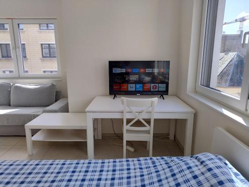 a room with a desk with a computer on it at Elegant Spacious Room with Open Kitchen, Steps from Luxembourg Train Station in Luxembourg