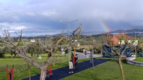 a group of people walking down a path with a rainbow in the background at Orion Guesthouse Telhado in Fundão