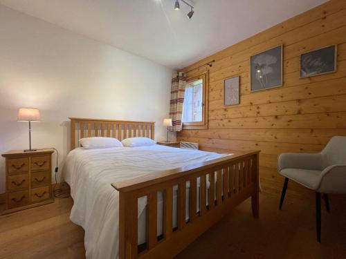 - une chambre avec un grand lit et un mur en bois dans l'établissement Appartement Samoëns, 3 pièces, 6 personnes - FR-1-624-23, à Samoëns