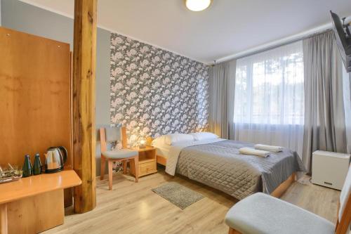 a hotel room with a bed and a window at Rezydencja Karnat I i II in Karpacz