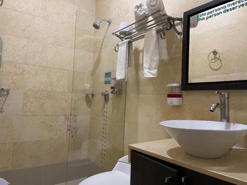 a bathroom with a shower and a sink and a toilet at Hotel Bolivariana Plaza Medellin in Medellín