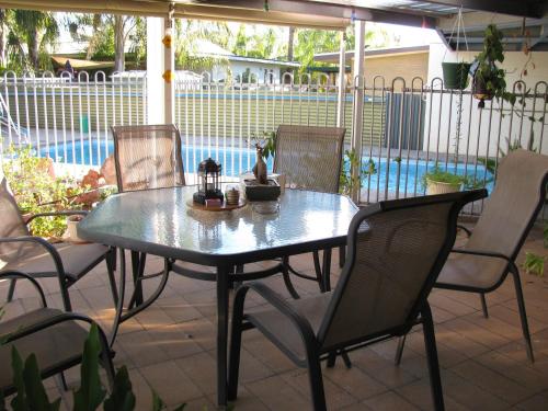 a table and chairs on a patio with a pool at Kathys Place Bed and Breakfast in Alice Springs