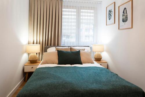 une chambre avec un grand lit avec deux lampes dans l'établissement Mieszkanie Jagiellońska Kładka przy Morzu i PKP, à Kołobrzeg