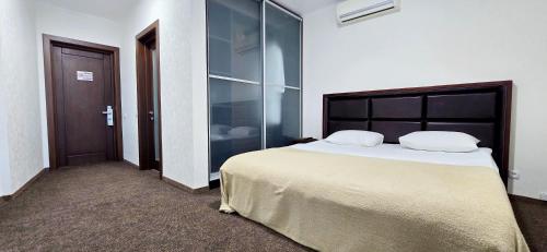 a bedroom with a large bed and a glass wall at Wellotel Chornomorsk in Chornomorsk