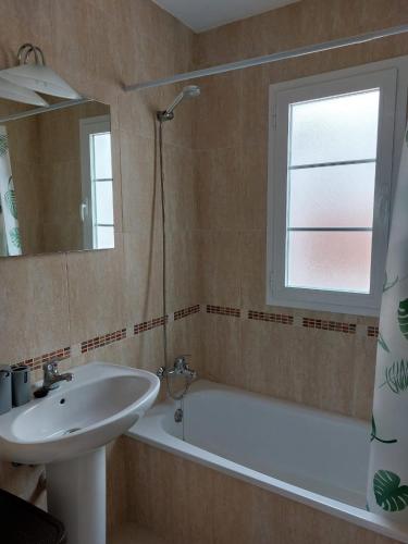 a bathroom with a sink and a tub and a mirror at Ático El Paraíso in Cómpeta