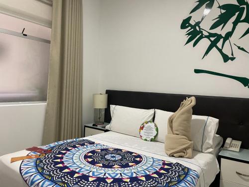 a bedroom with a bed with a colorful blanket on it at Hotel Bolivariana Plaza Medellin in Medellín