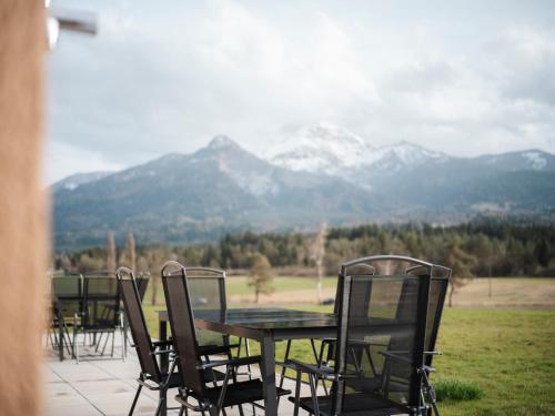 a group of chairs and a table with mountains in the background at Premium Apartments Monterra in Petschnitzen