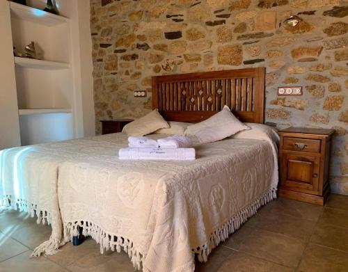 a bedroom with a bed with two towels on it at Casa Rural La Vertedera 3 in Villar de Ciervo