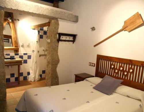 een slaapkamer met een bed en een boom erin bij Casa Rural la Vertedera 2 in Villar de Ciervo