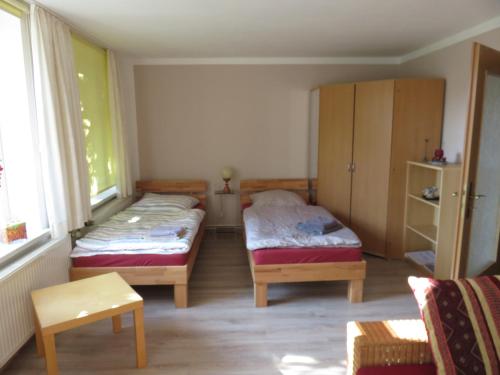 um pequeno quarto com 2 camas e uma janela em Hof Gerbert em Halenbeck