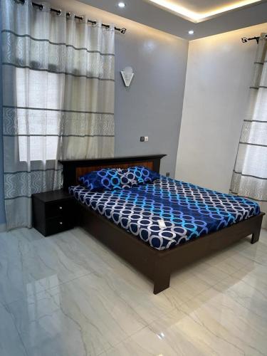 a bedroom with a bed with a blue comforter at Luxueuse cité in Bodjo