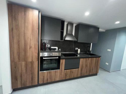 uma cozinha com armários de madeira e um forno com placa de fogão em San Giacomo Loft Apartment em Barletta