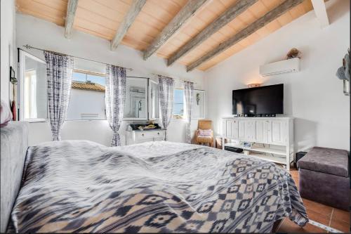 sypialnia z łóżkiem, biurkiem i telewizorem w obiekcie Villa Christiane w mieście Ses Salines