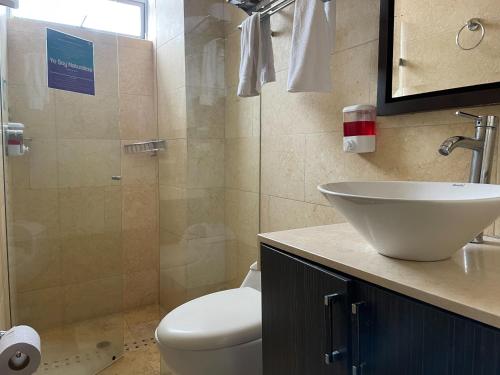 a bathroom with a sink and a toilet and a shower at Hotel Bolivariana Plaza Medellin in Medellín