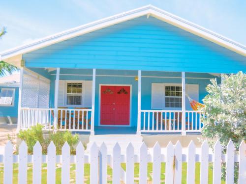 クライストチャーチにあるEndless Summer Beach House 4BR with Carの赤い扉と白い柵の青い家