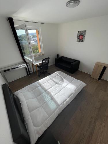 a bedroom with a large white bed and a desk at Room in Apartment next to ST Hbf in Stuttgart