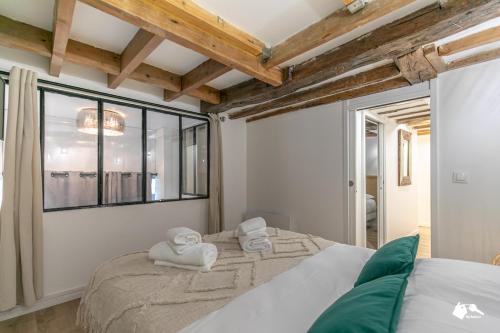 une chambre avec un grand lit et une fenêtre dans l'établissement MBA Splendide Appart 3 - Proche Musée du Louvre, à Paris