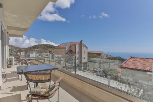 einen Balkon mit einem Tisch und einem Stuhl sowie Aussicht in der Unterkunft Villa White Beauty in Lapčići