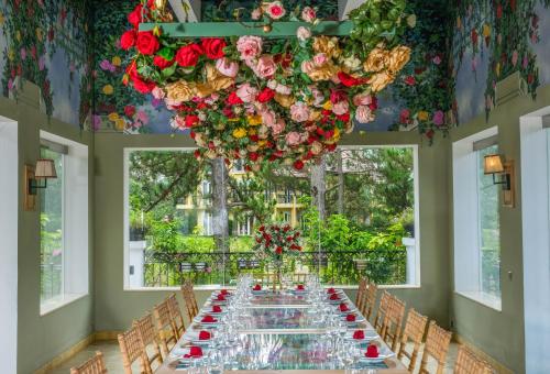 a long table in a room with flowers and a chandelier at Binh An Village Resort in Da Lat