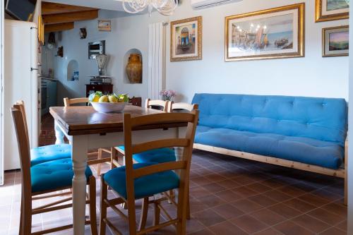 sala de estar con sofá azul y mesa en The House of Flowers, en Vietri