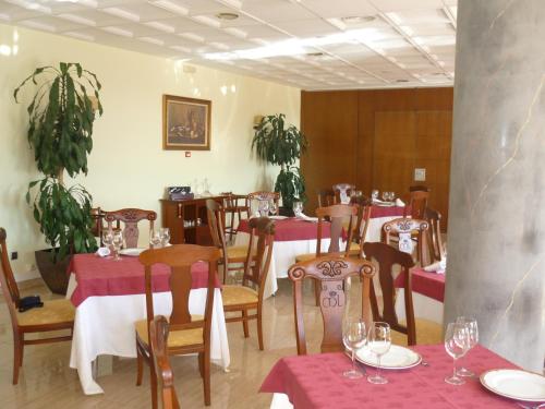 un restaurante con mesas y sillas con manteles rojos en Manrique de Lara en San Leonardo de Yagüe