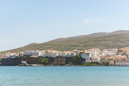 a group of white buildings on a hill next to the water at Stenies'nook in Steniaí