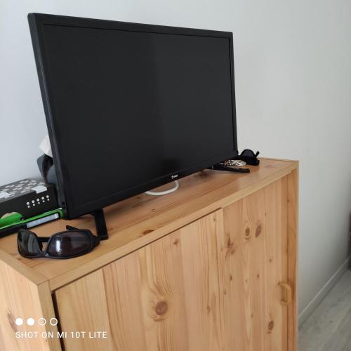 a flat screen tv sitting on top of a wooden cabinet at PATRICK in Damgan