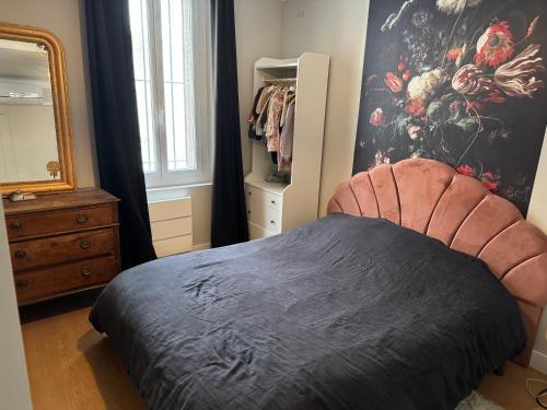 Schlafzimmer mit einem Bett, einer Kommode und einem Spiegel in der Unterkunft Maison climatisée intra-muros avec terrasse in Avignon
