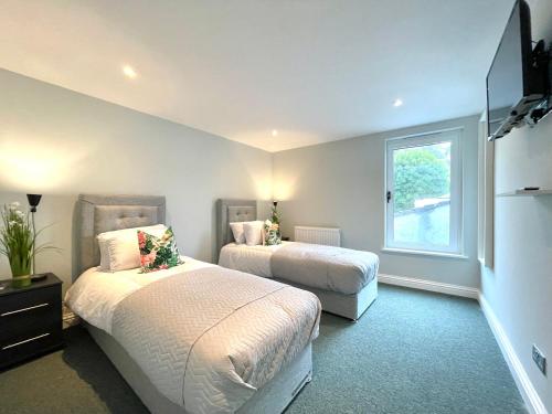 a bedroom with two beds and a window at Renovated 2 Bedroom Apartment With 2 Bathrooms in Bristol