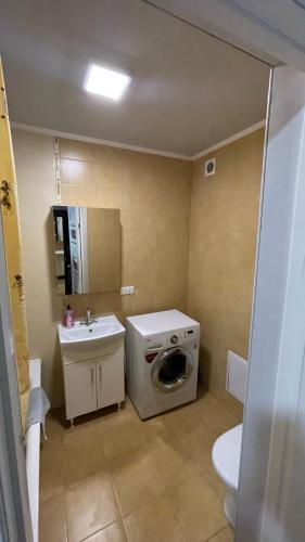 a bathroom with a washing machine and a sink at Квартира возле Автовокзала in Rivne