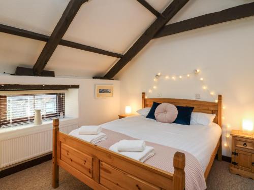 a bedroom with a wooden bed with lights on the ceiling at The Coach House in Haroldston West