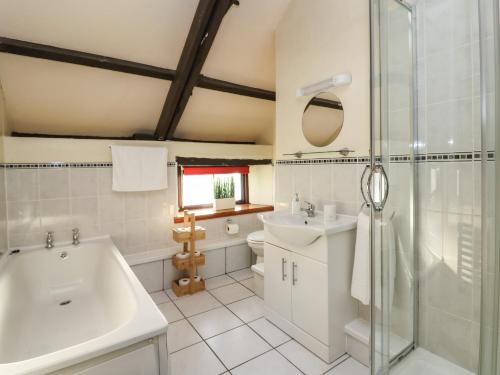a bathroom with a tub and a sink and a shower at The Coach House in Haroldston West