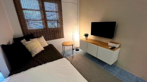 a bedroom with a bed and a flat screen tv at Alissia House in Ko Tao