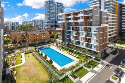 an aerial view of a large apartment building with a swimming pool at 2BR apt close to MQ shopping centre and university in Sydney